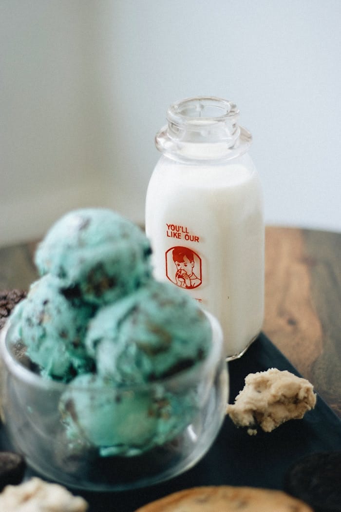 Artisan mint ice cream with a vintage milk bottle on a rustic wooden table.